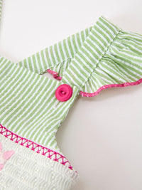 Green and white striped cotton girls dress detail with pink button and pink trim.