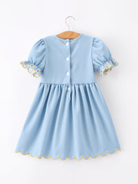 Blue puff-sleeve dress for girls with pencil applique, back buttons, and yellow scalloped hem.