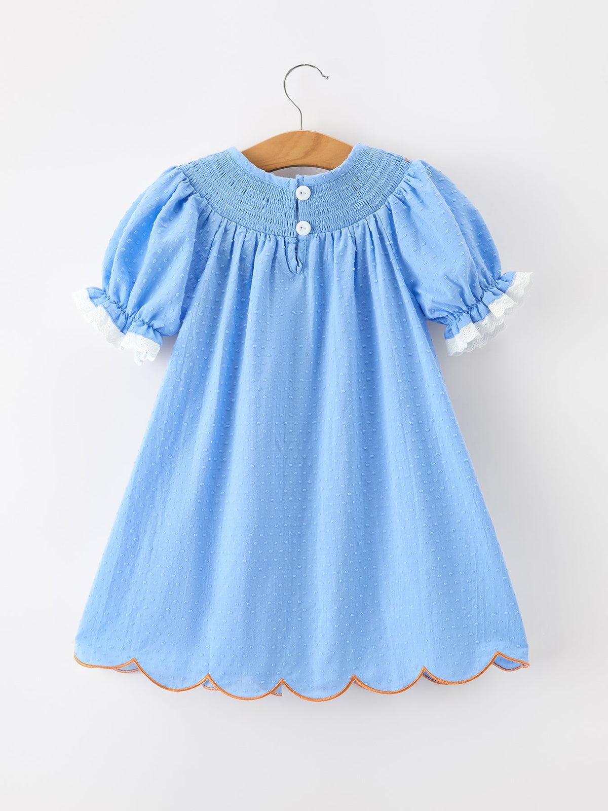 Blue baby girl dress on hanger with puff sleeves, lace trim, white buttons, dotted fabric and scalloped orange hem