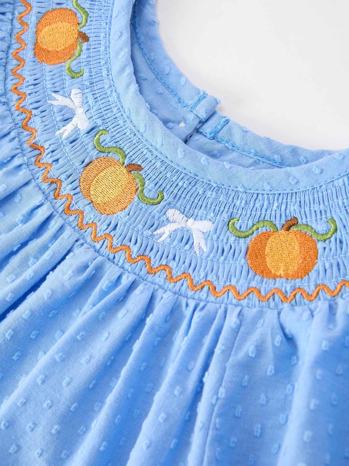 Blue baby girl dress with pumpkin embroidery, lace trim, and smocked neckline for fall holidays.