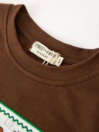 Inner neck label reading Rylee Faith Designs size 3 stitched into brown ribbed crew neckline collar