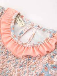 Fall floral girls dress with smocked bodice, ruffled neckline, and bow accents in pink pastel.