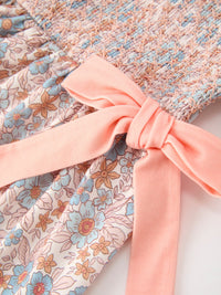 Fall floral girls dress with smocked bodice, ruffle neckline, and pink bow sash.