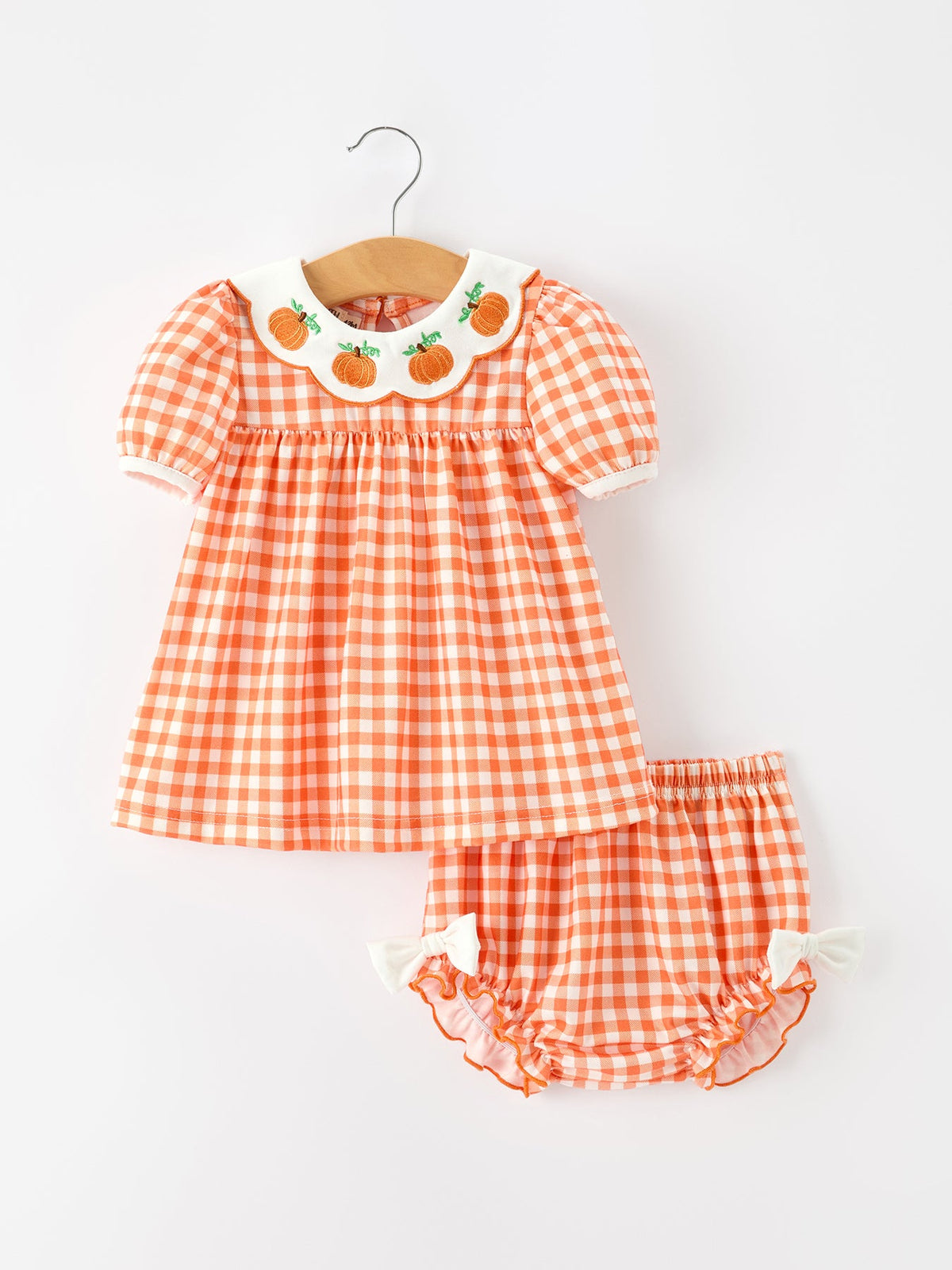 Orange gingham girls pumpkin set with puff sleeves, scalloped collar with pumpkin appliques, and ruffled bloomers with bows for Thanksgiving or Halloween.