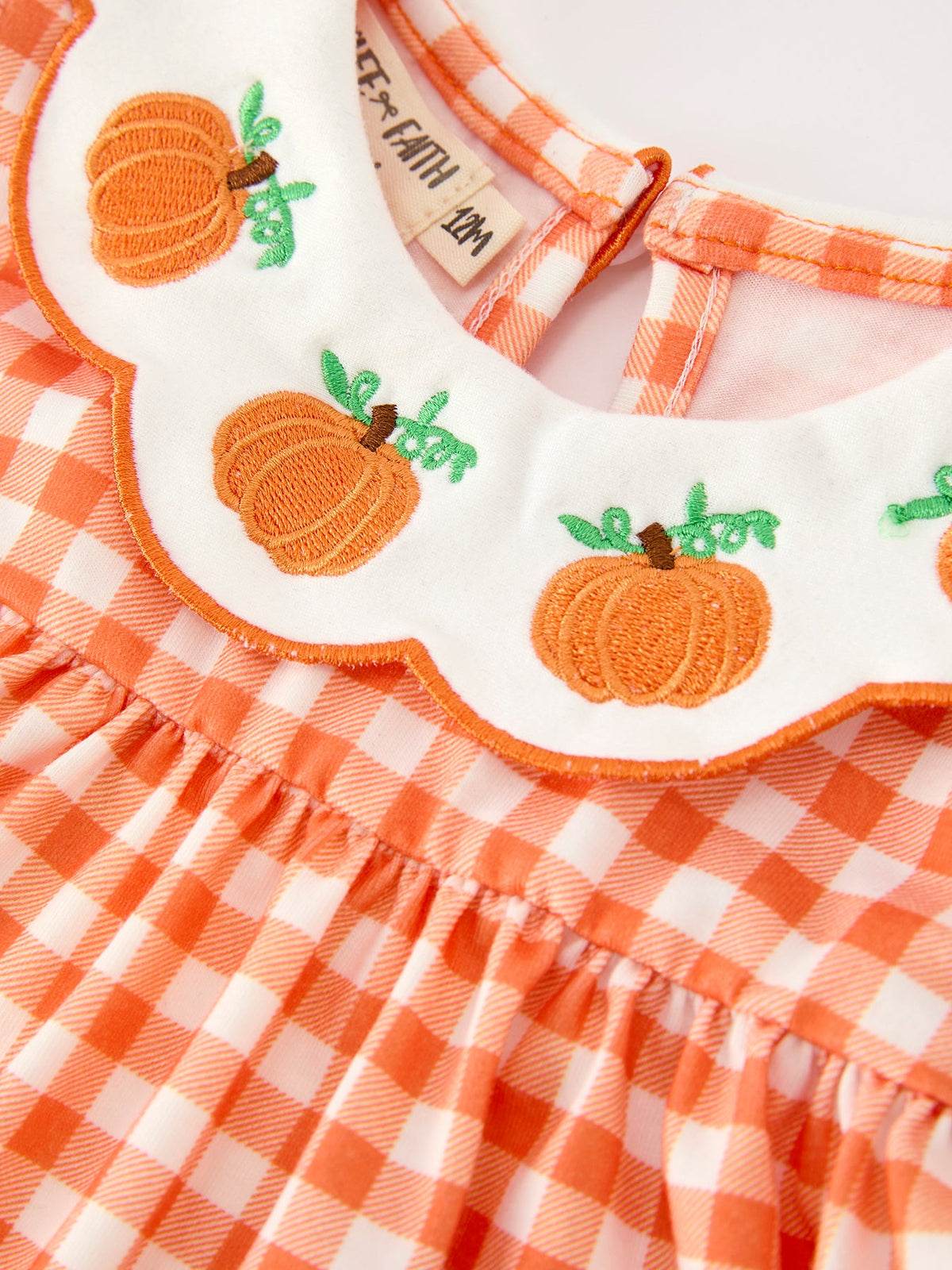Orange gingham girls' outfit with embroidered pumpkin appliqués on scalloped Peter Pan collar, perfect for Thanksgiving or Halloween.