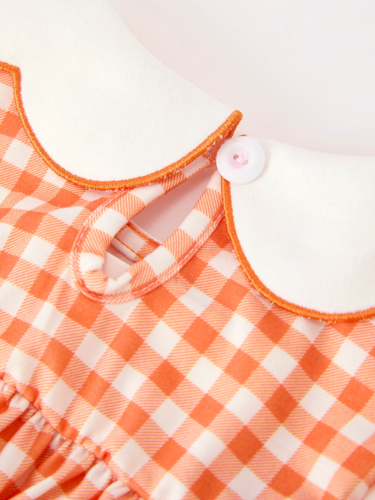 Orange gingham girls dress collar with white Peter Pan neck, orange trim, keyhole detail, and white button.
