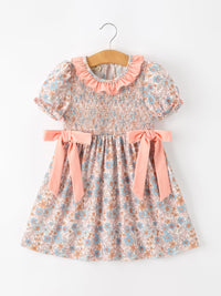 Fall floral girls dress with smocked bodice, pink ruffle neckline, puff sleeves, and pink bow waist ties.