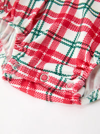 Red green plaid baby girl bubble romper featuring elastic leg openings and silver snap buttons for easy dressing during the holidays.