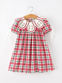 Red and green plaid baby girl Christmas dress with embroidered floral wreath collar and white ribbon sleeves.