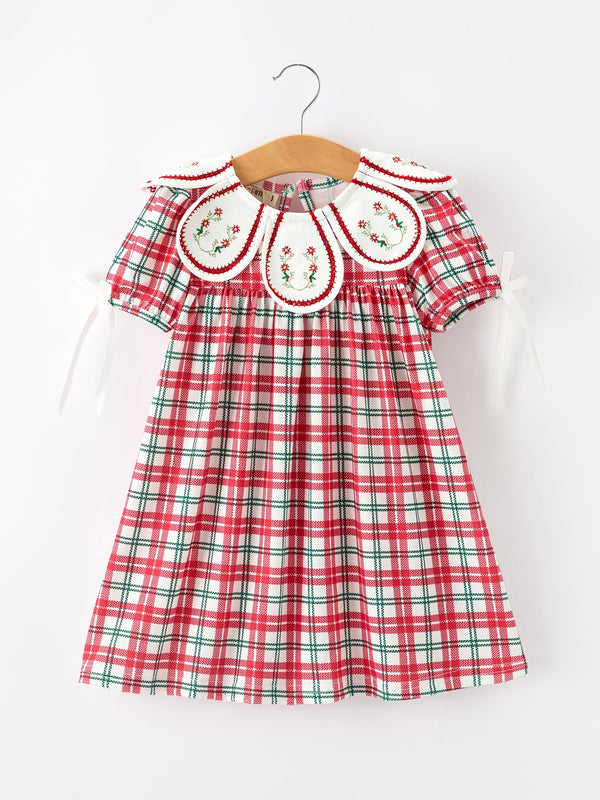 Red and green plaid baby girl Christmas dress with embroidered floral wreath collar and white ribbon sleeves.