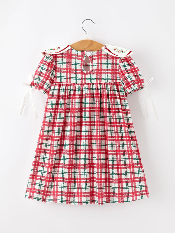 Back view of red green plaid baby girl dress with embroidered floral collar and white ribbon sleeve ties. Festive holiday outfit.