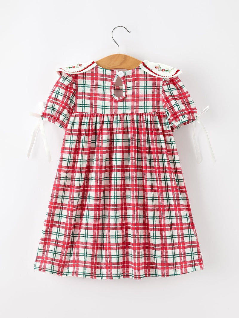 Back view of red green plaid baby girl dress with embroidered floral collar and white ribbon sleeve ties. Festive holiday outfit.