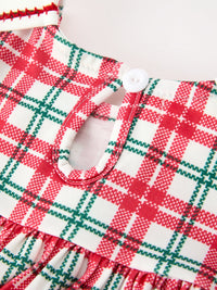 Red and green plaid baby girl dress neckline featuring a keyhole back with a white button and festive holiday fabric detail.