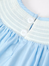 Light blue girls dress featuring white smocked neckline, white button back closure, and gathered fabric details.