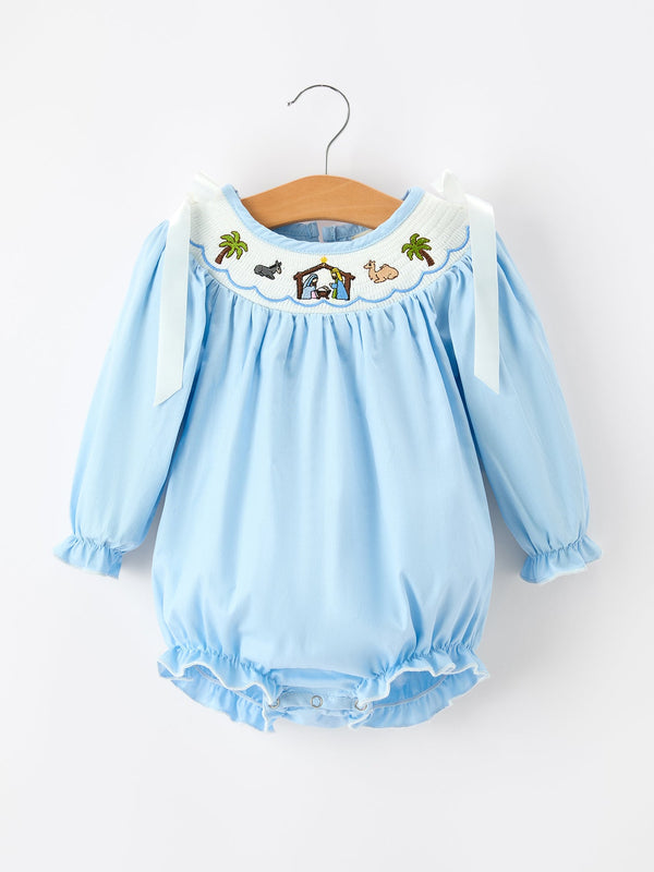 Boca blue baby bubble romper with smocked nativity embroidery, palm trees, animal motifs, and white bow shoulder straps.