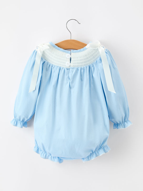 Boca blue baby bubble romper with white smocked neckline, long puff sleeves, and white bow shoulder straps on a hanger.