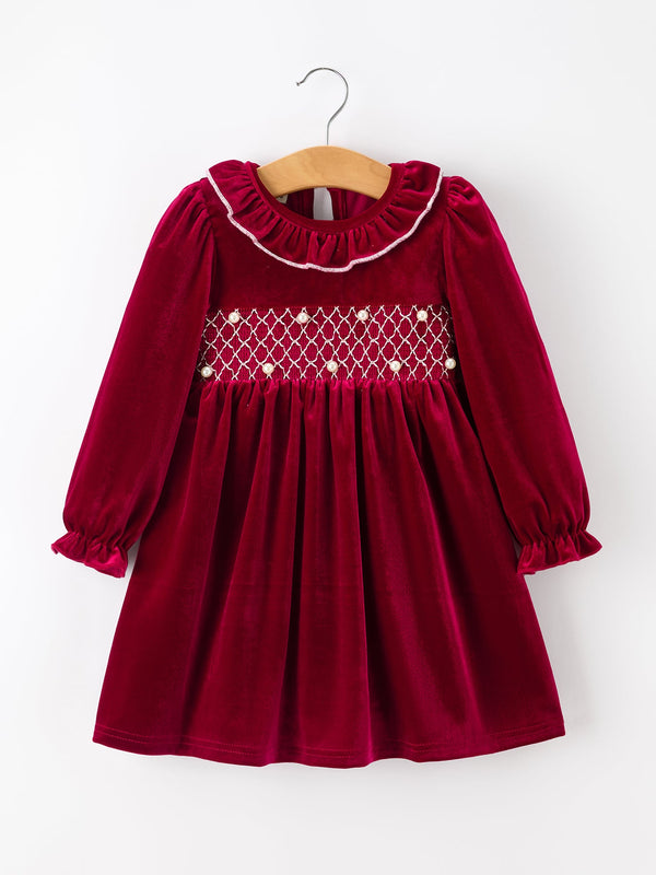 Burgundy velvet girls Christmas dress with smocked pearl bodice, ruffled neckline, and long puff sleeves.