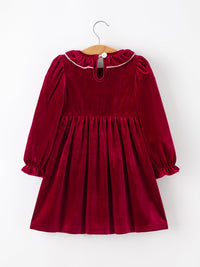 Burgundy velvet girls dress with long puff sleeves, ruffled neckline, and smocked waist featuring pearl accents for the holidays.