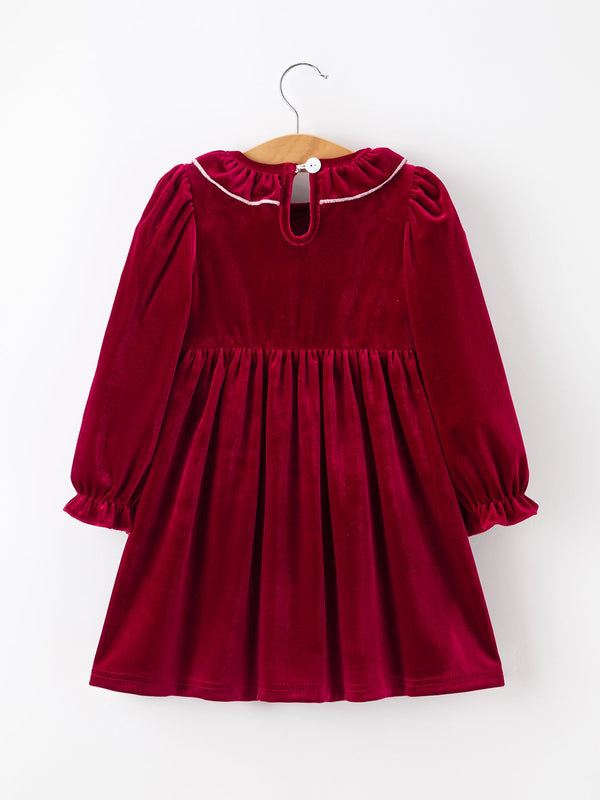 Burgundy velvet girls dress with long puff sleeves, ruffled neckline, and smocked waist featuring pearl accents for the holidays.