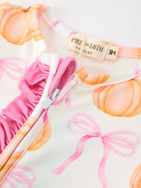 Baby girls pumpkin bow romper featuring pink ruffled zipper trim, orange pumpkin print, and enclosed feet for cozy fall wear.