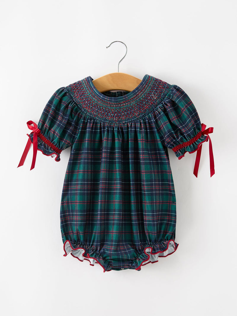 Girls Christmas plaid smocked bubble romper with green and navy pattern, puff sleeves, red ribbon ties, and ruffled leg openings.