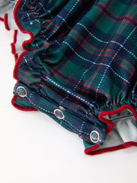 Green and navy plaid Christmas bubble romper with red trim, smocked neckline, and metal snap closures for girls.