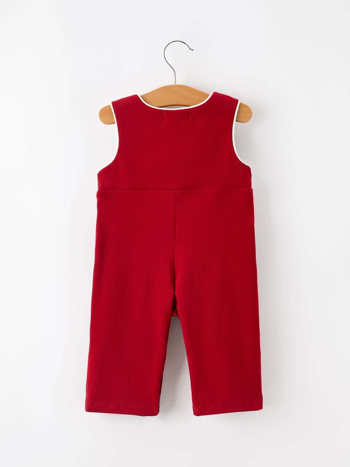 Back view of red baby boys Christmas smocked jonjon romper with white contrast piping on hanger.