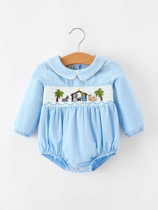 Blue baby boy romper with embroidered nativity scene on smocked chest panel and white trim Peter Pan collar.