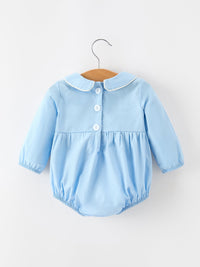 Blue baby boy cotton romper back view with Peter Pan collar, white buttons, and smocked chest panel for Christmas.