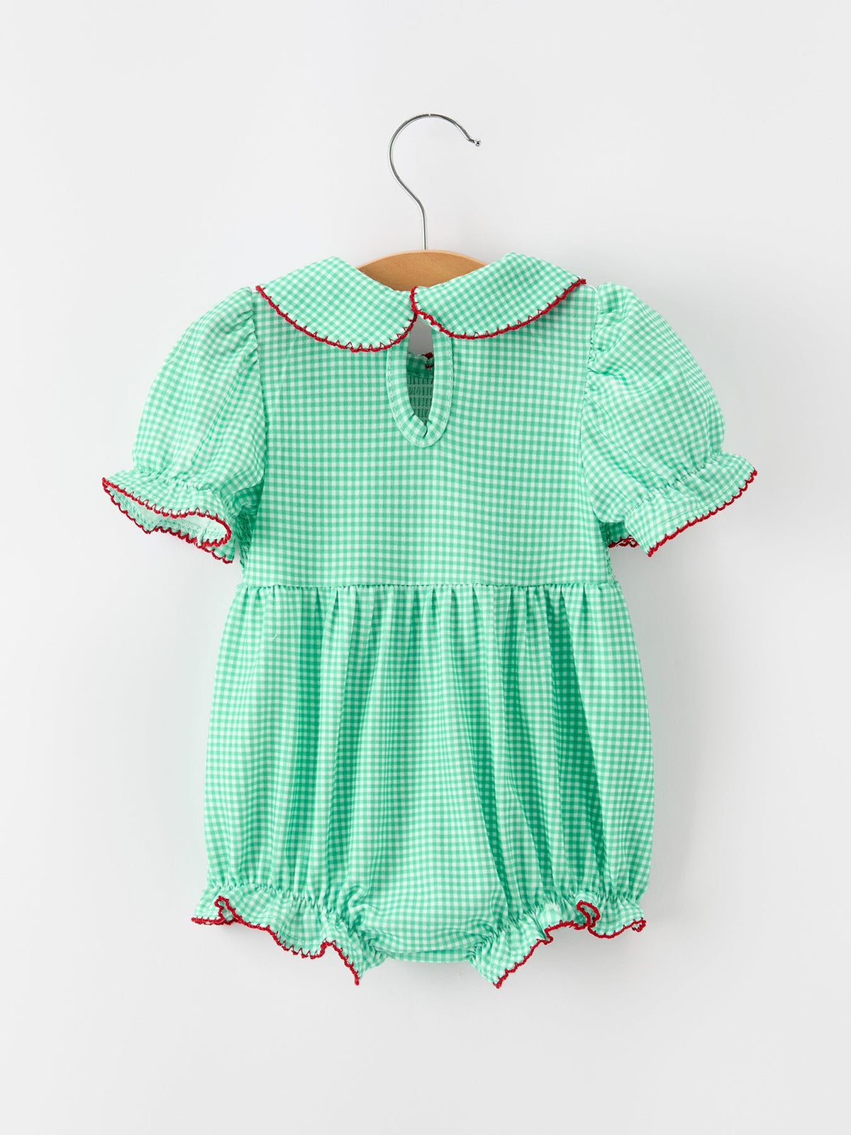 Green gingham bubble romper with Peter Pan collar, puff sleeves, and red trim for festive holiday wear.
