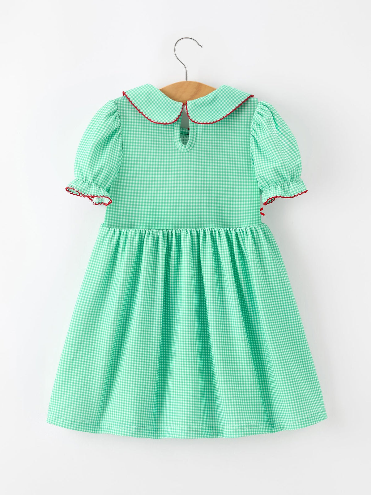 Green gingham girls Christmas dress with red-trimmed Peter Pan collar, puff sleeves, and smocked bodice.