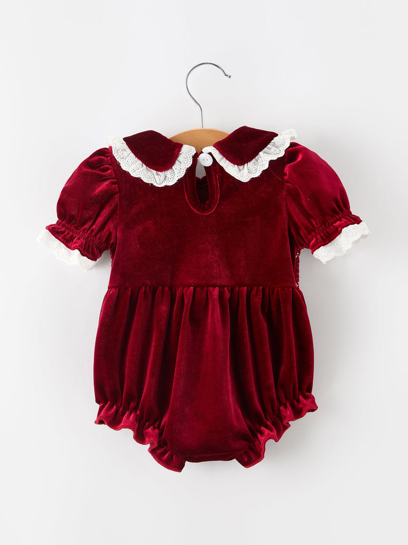 Burgundy velvet baby girl romper with lace-trim Peter Pan collar, puff sleeves, and ruffled hem for festive holiday wear.