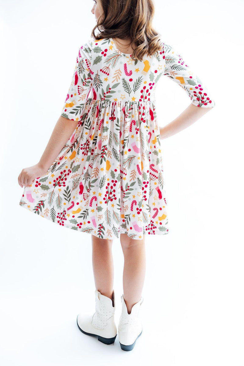 Back view of a girl in the 'Holly Jolly Christmas' 3/4 Sleeve Pocket Christmas Twirl Dress for Girls, emphasizing the twirl skirt and festive patterns.