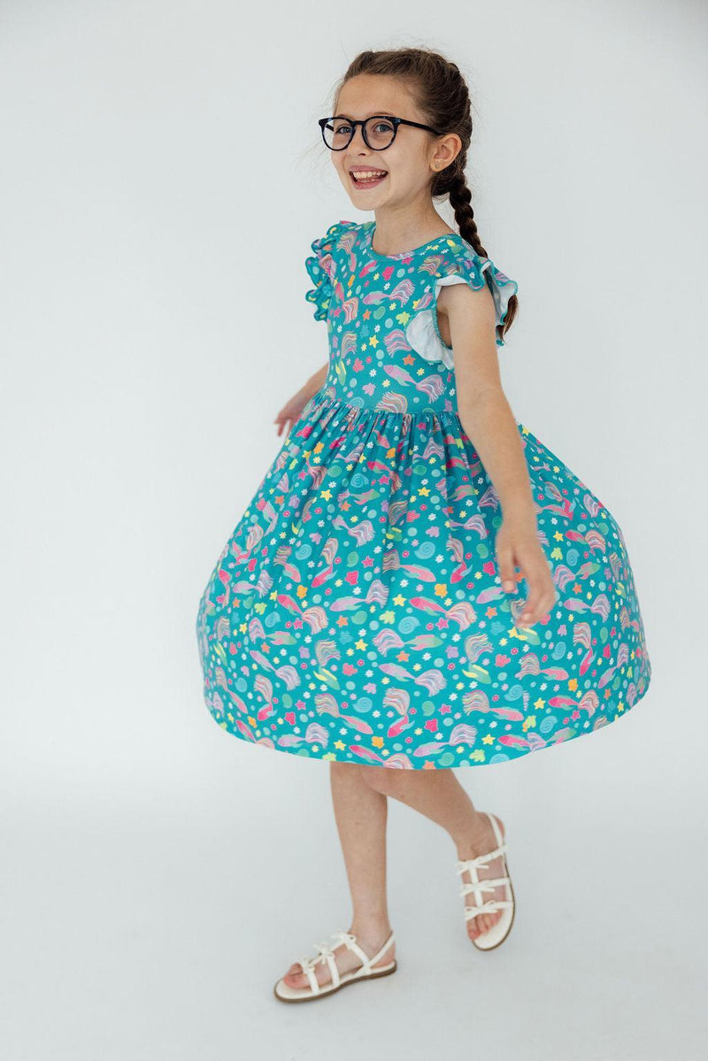 Close-up of the unique scoop back of Betta Blooms Flutter Sleeve Twirl Dress, designed for easy dressing.