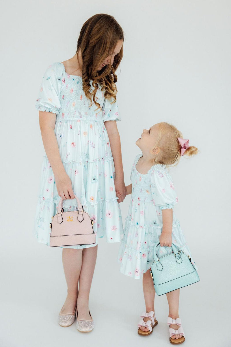 Close-up of the adorable smocked bodice of the Butterfly Ballet Smocked Ruffle Dress by Mila & Rose, showcasing its flexible fit and playful design.
