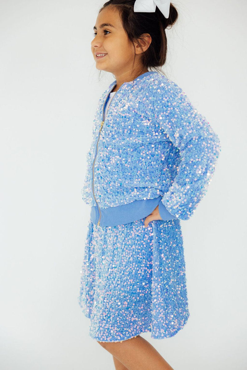 Side view of a smiling child in a Light Blue Velvet Sequin Jacket, confidently showcasing the dazzling sequins and chic outfit.