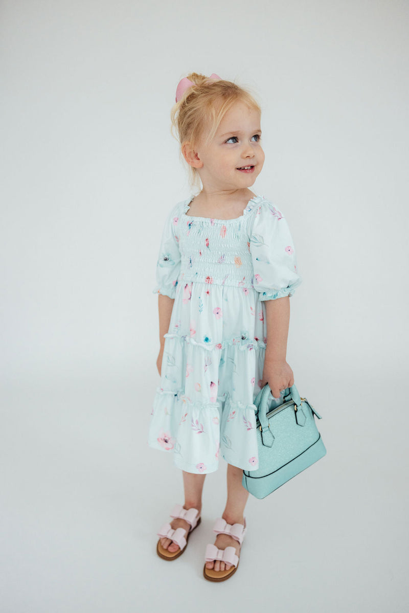 The Butterfly Ballet Smocked Ruffle Dress by Mila & Rose displayed neatly, highlighting its soft fabric and stylish design, ideal for any little princess.