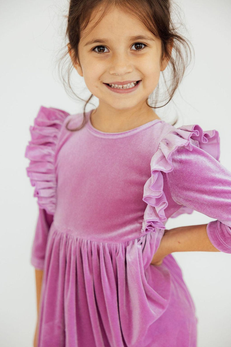 Close-up of a girl in the Carnation Pink Velvet Ruffle Twirl Dress by Mila & Rose, featuring soft velvet material and stylish ruffle details.
