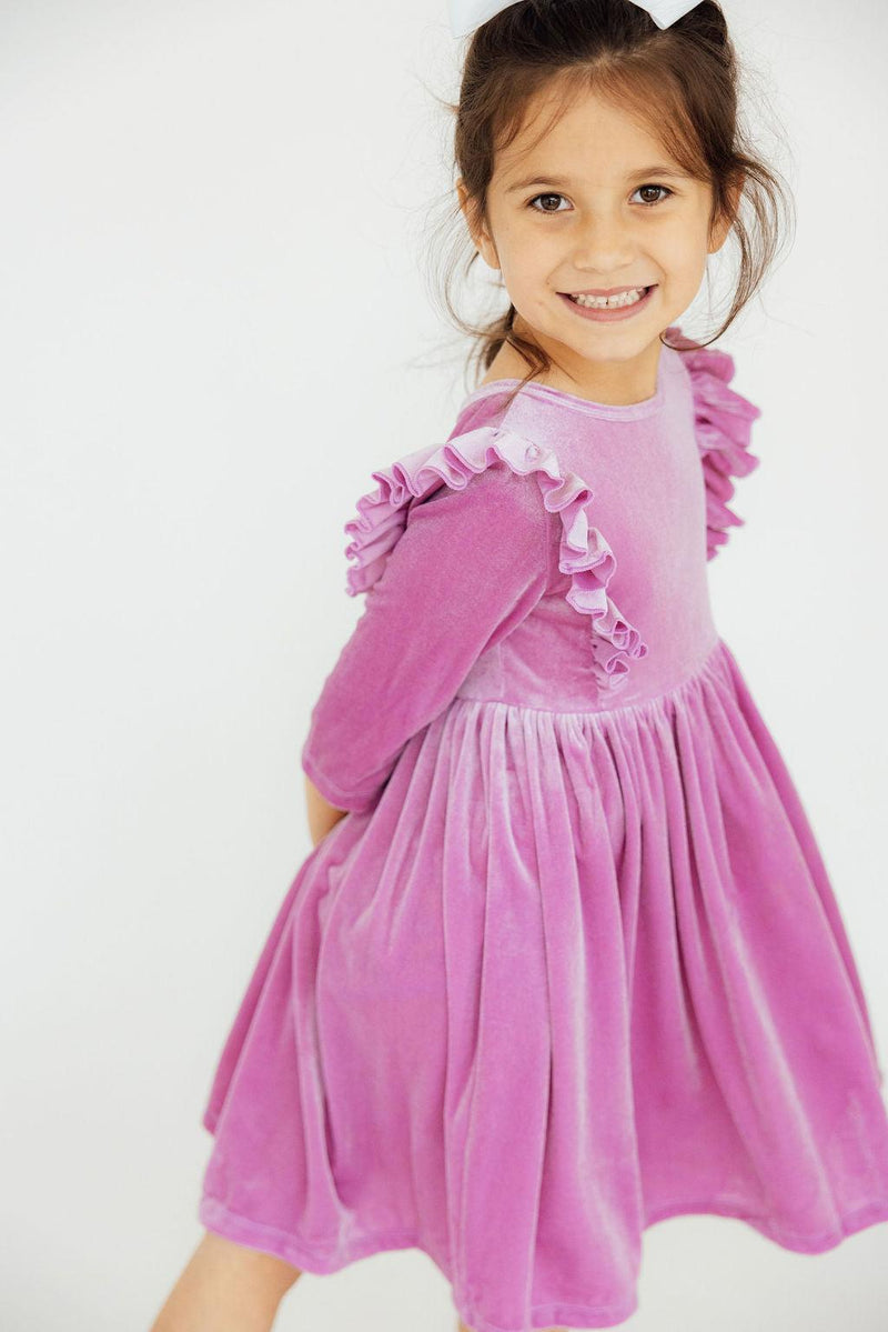 Smiling girl in the Carnation Pink Velvet Ruffle Twirl Dress by Mila & Rose, elegantly moving and showcasing the dress's flowy design.