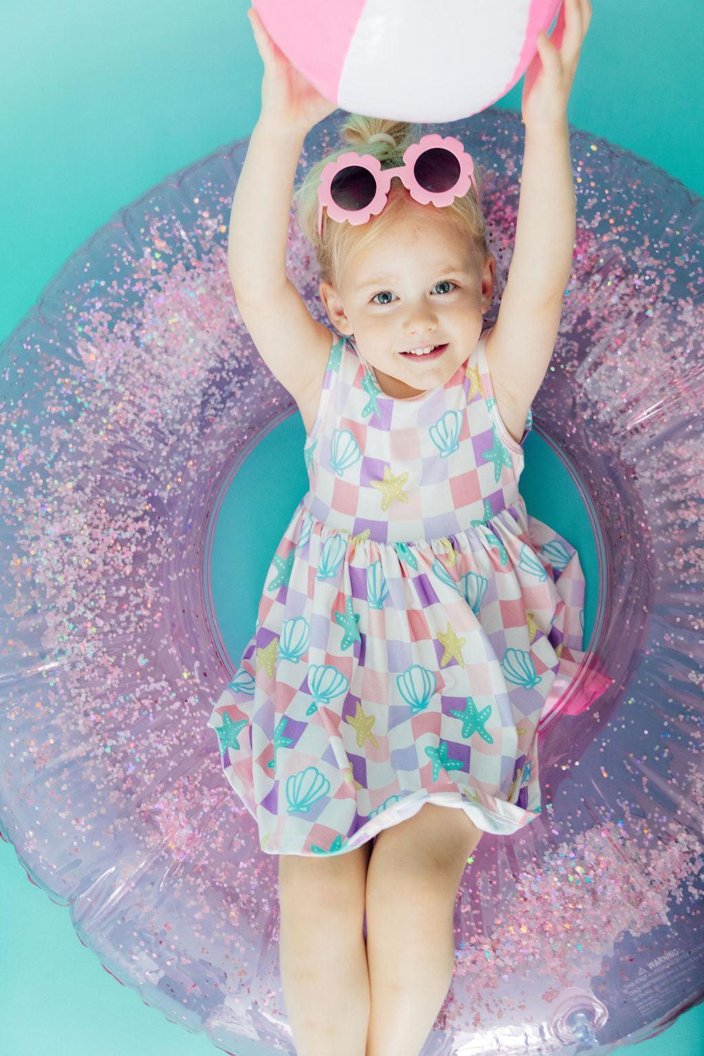 Girl in a Beach Days Tank Twirl Dress by Mila & Rose twirling happily, showcasing its stylish design and comfortable fit.