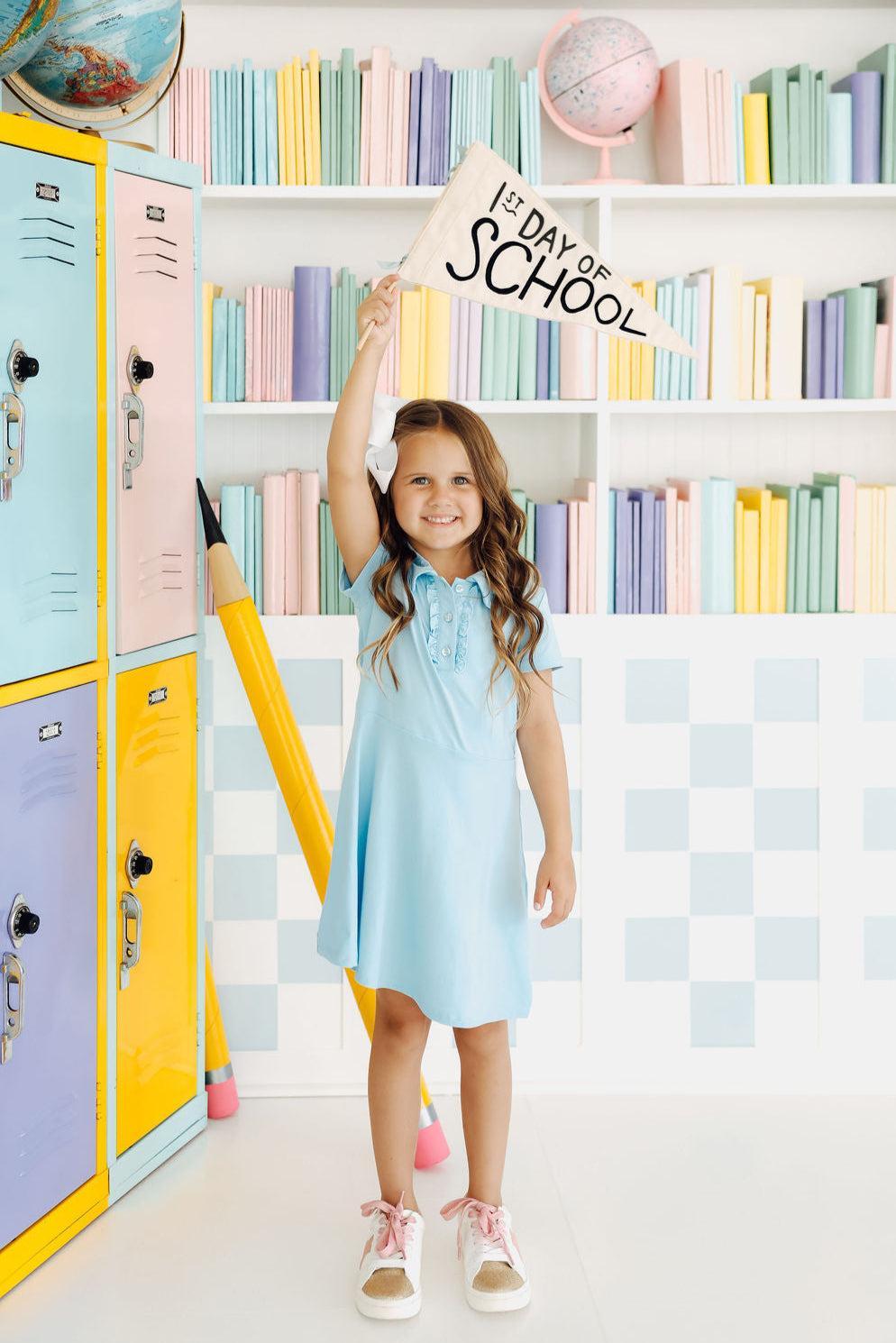 Bluebird S/S Polo Dress on a child, showcasing the ruffled collar and button placket design from Mila & Rose.
