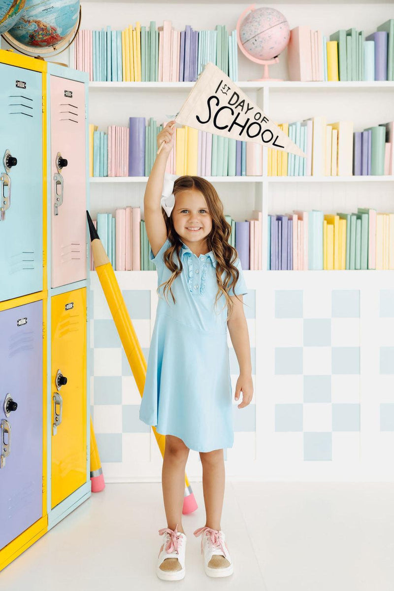 Bluebird S/S Polo Dress on a child, showcasing the ruffled collar and button placket design from Mila & Rose.