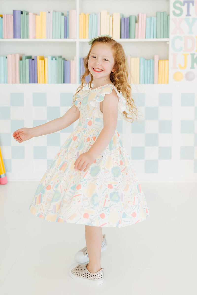 The versatile Campus Cutie Flutter Sleeve Twirl Dress for Girls, ideal for pairing with shorts or leggings for any adventure.