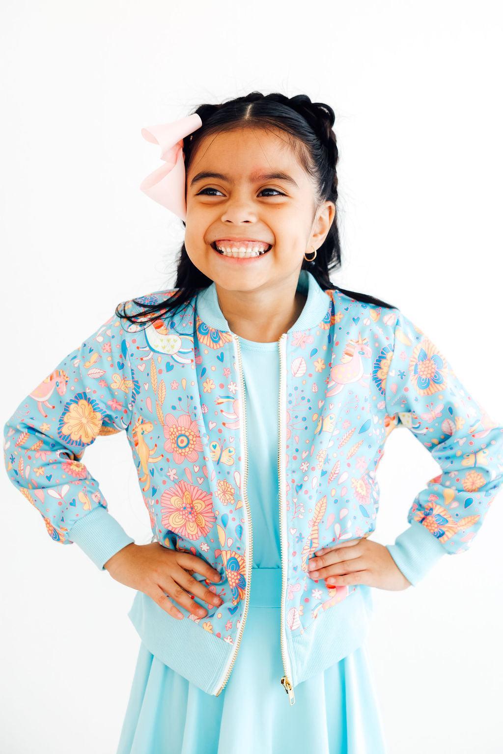 Blue Retro Unicorns Satin Jacket by Mila & Rose displayed on a model, showcasing its playful design and shiny finish.