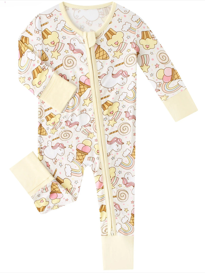 A baby long-sleeve footless zip-up sleeper with a cream background and a playful print of unicorns, ice cream cones, rainbows, and stars. The sleeves, cuffs, and zipper trim are solid cream.