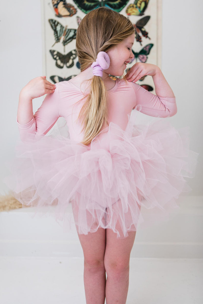 Girl's Ballet Pink 3/4 Tutu Leotard laid flat, highlighting its soft fabric and playful design for future prima ballerinas.