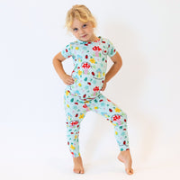 Child wearing The Second-Skin 2-Piece Short Sleeve Pajama in light blue with mushroom and floral print.