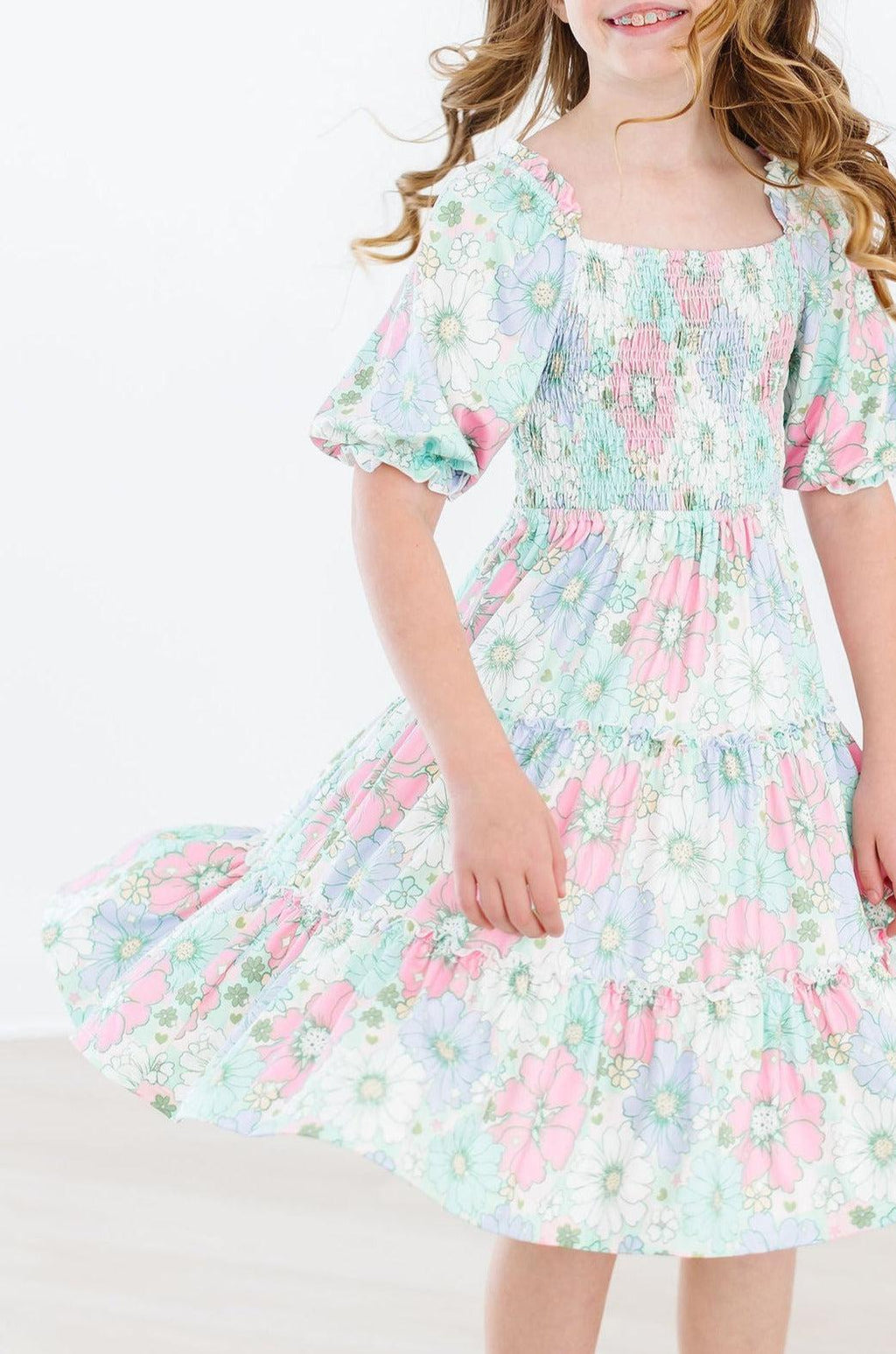 Delightful Minty Meadow Smocked Ruffle Dress featuring vibrant floral patterns and a twirl-worthy skirt, perfect for any special occasion.
