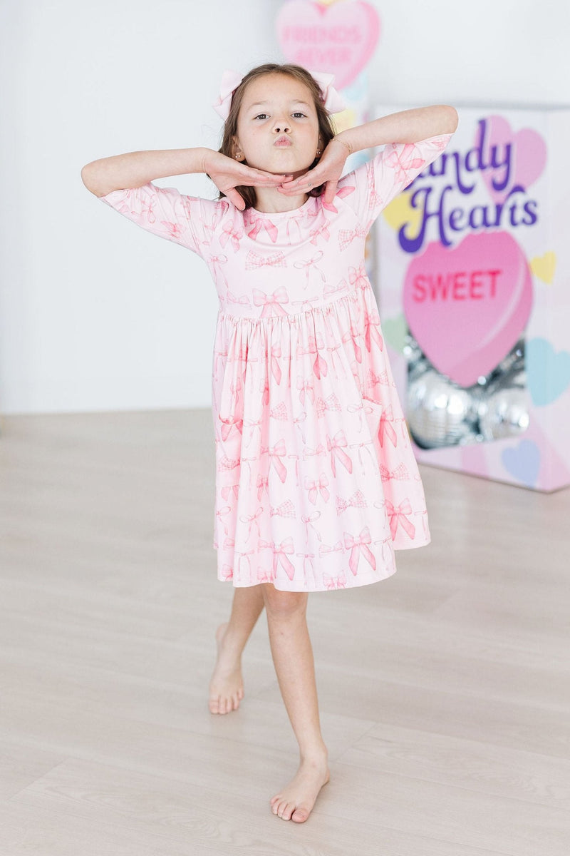 Blushing Bows 3/4 Sleeve Pocket Twirl Dress with a scoop back design, perfect for easy dressing and stylish comfort.