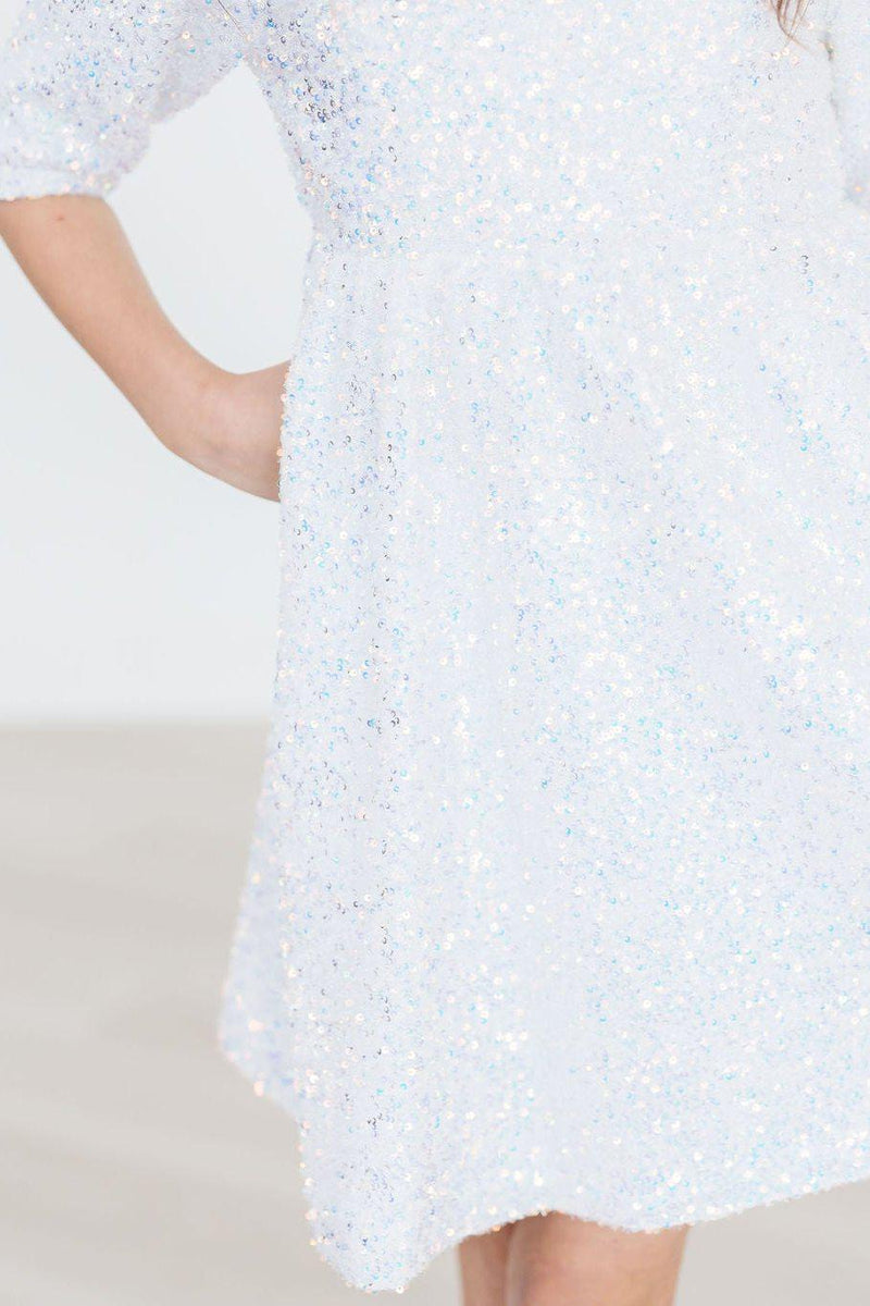 Close-up view of a dazzling white sequin party dress, emphasizing the intricate sequins that add elegance and shine.